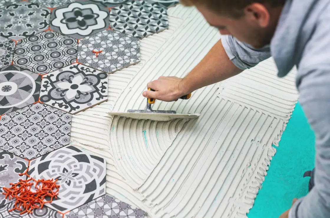 tile installation and selection - man installing patterned tiles on floor